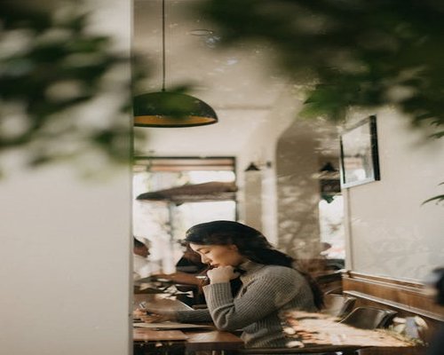Person relaxing in a modern cafe with soft morning light